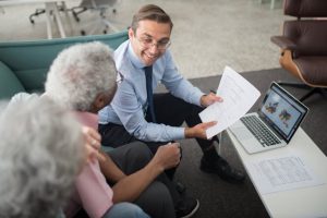 assets in a trust, image of senior couple meeting with businessman