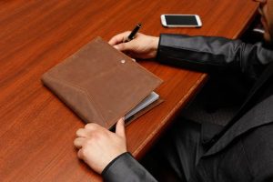 What Is a Usufruct in Louisiana, image of man's arms pen in hand with binder in from of him on a table
